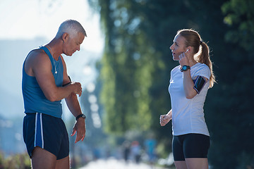 Image showing jogging couple planning running route  and setting music