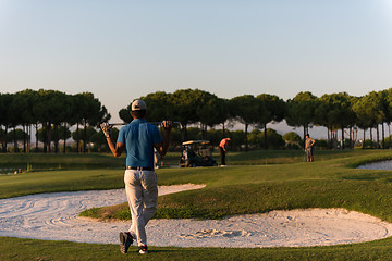 Image showing golfer from back at course looking to hole in distance