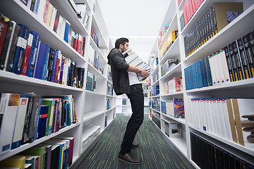 Image showing Student holding lot of books in school library