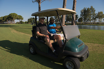 Image showing golf players driving cart at course