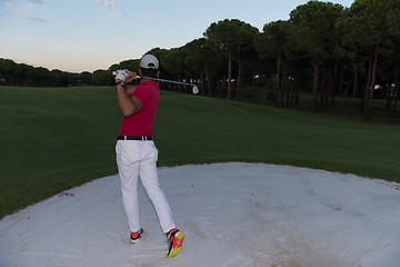 Image showing golfer hitting a sand bunker shot on sunset