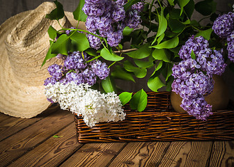 Image showing Still-life with a bouquet of lilacs and a straw hat, close-up