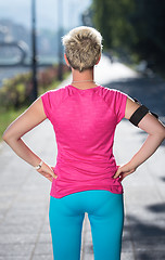 Image showing jogging woman setting phone before jogging