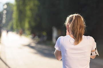 Image showing jogging woman setting phone before jogging