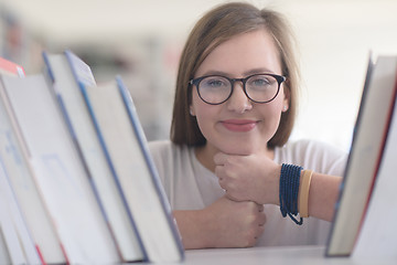 Image showing portrait of famale student selecting book to read in library