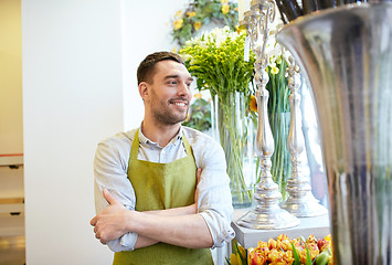 Image showing happy smiling florist man standing at flower shop