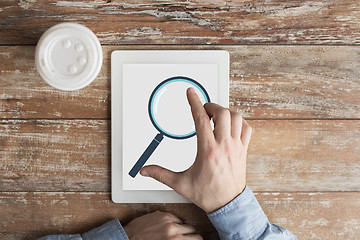 Image showing close up of male hands with magnifier on tablet pc