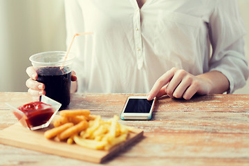 Image showing close up of woman with smart phone and fast food