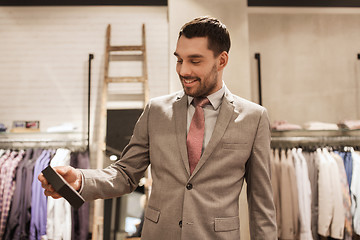 Image showing happy man holding little box in clothing store