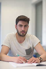 Image showing male student taking notes in classroom