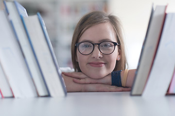 Image showing portrait of famale student selecting book to read in library