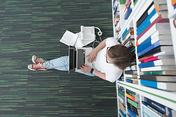 Image showing female student study in library, using tablet and searching for 