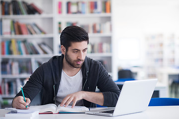 Image showing student in school library using laptop for research