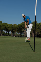 Image showing golf player hitting shot at sunny day