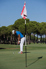 Image showing golf player hitting shot at sunny day