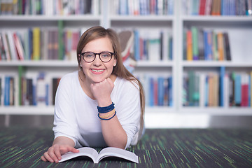 Image showing female student study in library, using tablet and searching for 