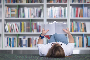 Image showing female student study in library, using tablet and searching for 