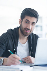 Image showing student in school library using laptop for research