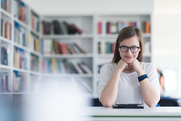 Image showing female student study in school library, using tablet