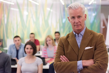 Image showing portrait of  teacher with students group in background