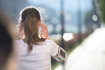 Image showing jogging woman setting phone before jogging