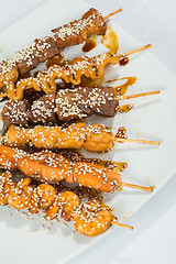 Image showing Grilled juicy skewered shashlik on a plate, sesame