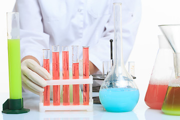 Image showing hands holding test tubes with chemical elements. 