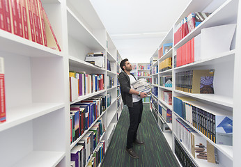 Image showing Student holding lot of books in school library