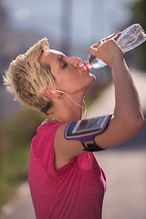 Image showing woman drinking  water after  jogging