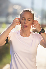 Image showing jogging woman setting phone before jogging