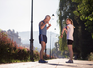 Image showing jogging couple planning running route  and setting music