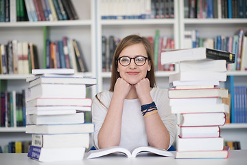 Image showing female student study in library, using tablet and searching for 