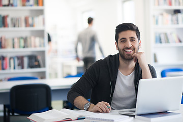 Image showing student in school library using laptop for research