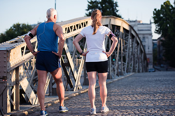 Image showing jogging couple planning running route  and setting music