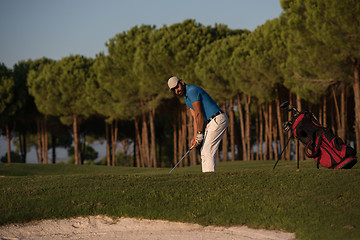 Image showing golfer hitting a sand bunker shot on sunset