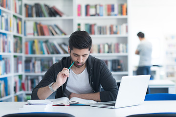 Image showing student in school library using laptop for research