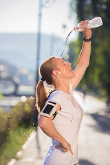 Image showing woman drinking  water after  jogging