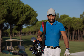 Image showing golfer  walking and carrying golf  bag