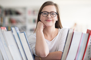 Image showing portrait of famale student selecting book to read in library