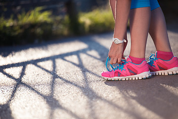 Image showing Closeup of woman tying running shoe