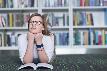 Image showing female student study in library, using tablet and searching for 