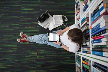 Image showing female student study in library, using tablet and searching for 