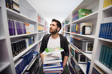 Image showing Student holding lot of books in school library