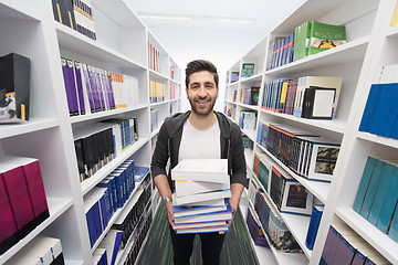 Image showing Student holding lot of books in school library