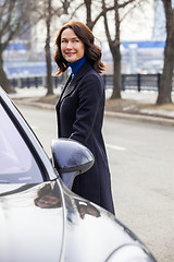 Image showing woman in a dark coat near car