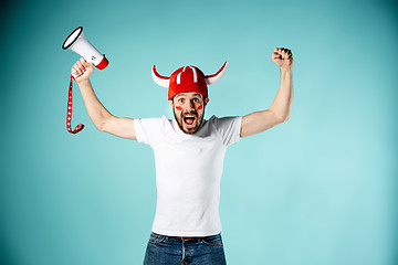 Image showing The football fan with mouthpiece over blue