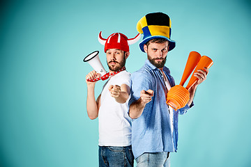 Image showing The two football fans with mouthpiece over blue