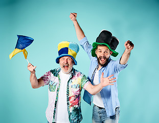 Image showing The two football fans with a flag of Ukraine over blue