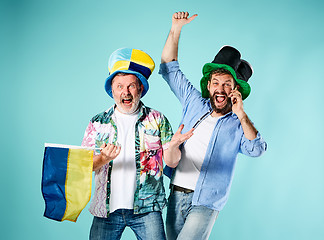 Image showing The two football fans with a flag of Ukraine over blue