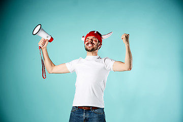 Image showing The football fan with mouthpiece over blue